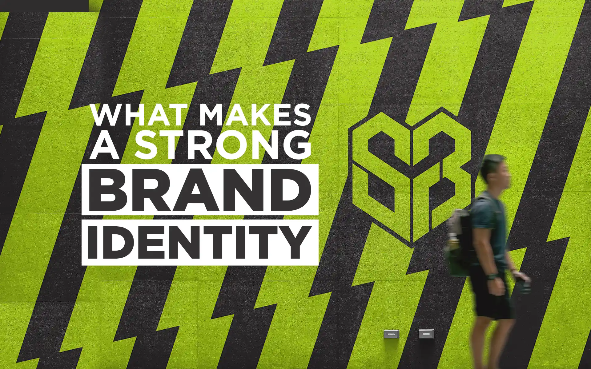 Strong brand identity: what makes a strong brand identity post graphic featuring black and lime green striped wall artwork with bold typography